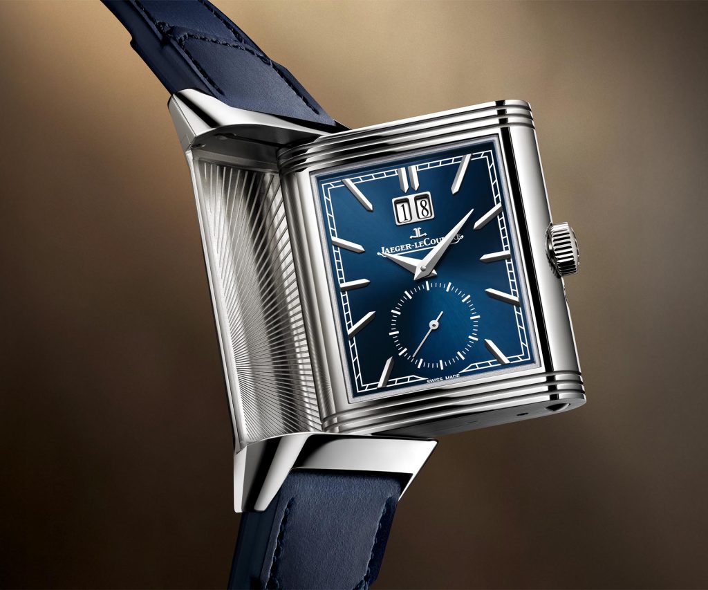 Jaeger-LeCoultre Reverso Tribute Geographic in steel with blue sunray dial, applied hour markers, small seconds at 6 o'clock, and large date display at 12 o'clock position.