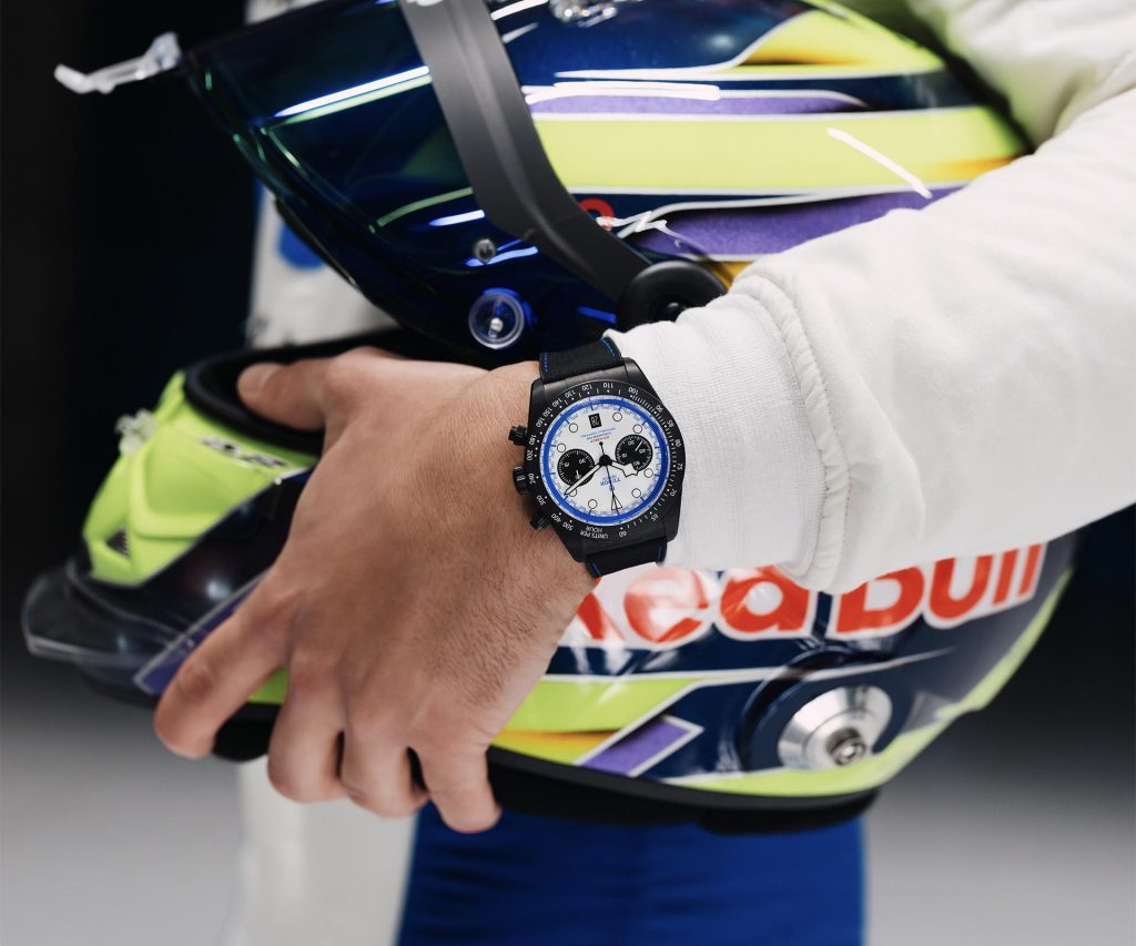 Close-up of racing driver's hand wearing TUDOR Black Bay Chrono Carbon 25 with racing suit